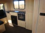 Interior shot of a Thorpe Thoroughbred finished in Canadian Maple complimented by the granite look worktops and slate style flooring.